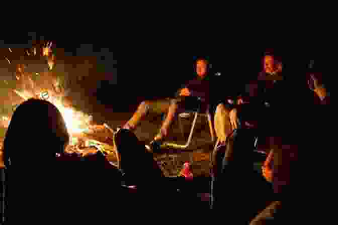 A Group Of Friends Sitting Around A Campfire Under A Starry Night Sky 1 000 Places To See In The United States And Canada Before You Die